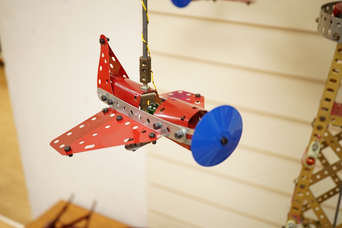 A Meccano model of a fairground ride, incorporating an electric motor in the base and lighting throughout, built in the style of a shop display centrepiece, approx 106cm high, 85cm diameter